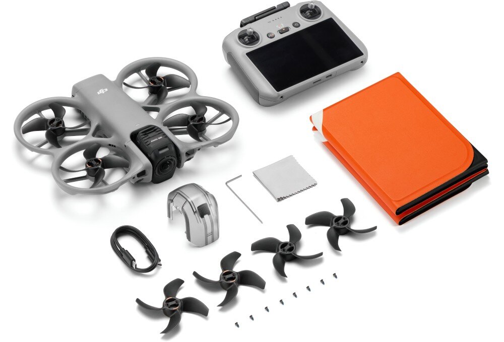 Na obrazie znajduje się zestaw drona z aparaturą sterującą, czterema śmigłami, kablem, ładowarką, kluczem, śrubkami, ściereczką oraz pomarańczowym etui. Dron ma wbudowaną osłonę śmigieł i widoczne logo DJI.