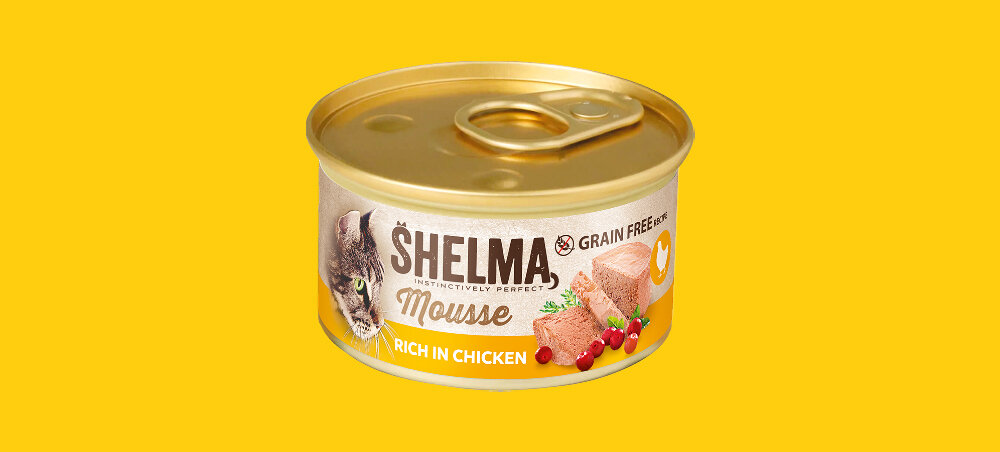 Puszka karmy dla kota marki SHELMA o smaku kurczaka z żurawiną i tymiankiem, z napisem \'RICH IN CHICKEN\' i \'GRAIN FREE\'. Na etykiecie widoczny jest wizerunek kota oraz kawałki mięsa z ziołami i żurawiną.