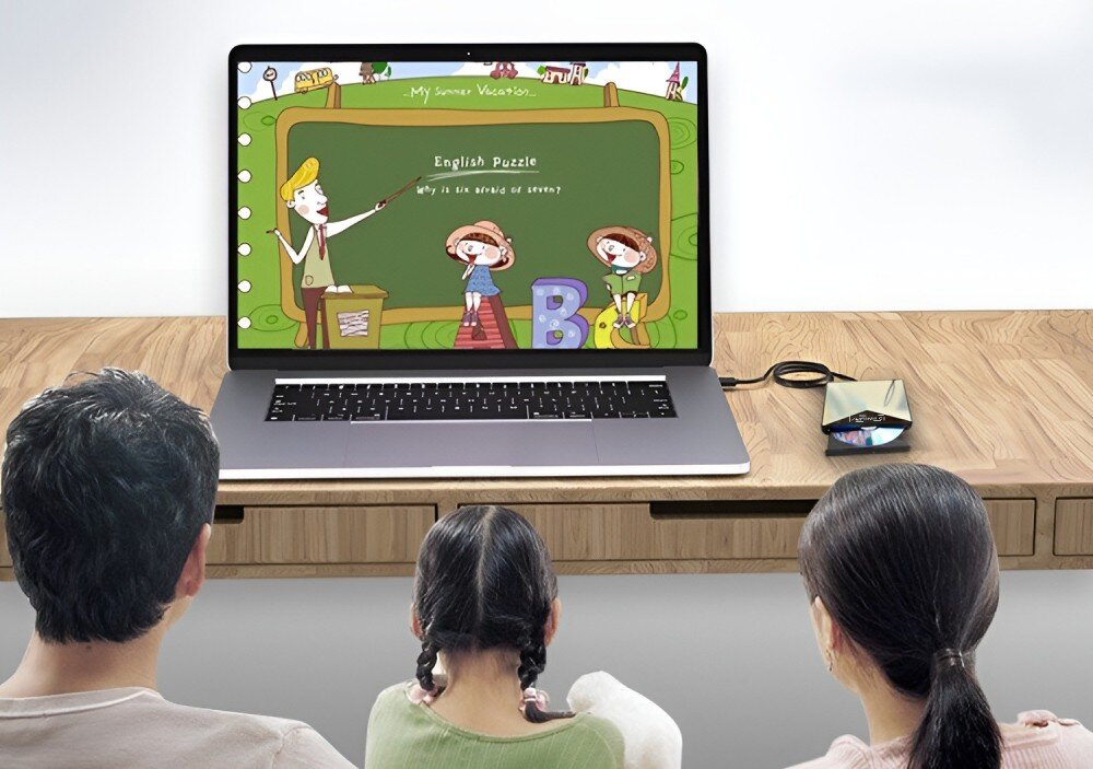Napęd ZENWIRE SY881 Rodzina – dwie osoby dorosłe i dziecko – siedzi przed dużym laptopem, na którym wyświetlana jest bajka. Napęd optyczny jest podłączony do laptopa, interfejs, przepustowość, podłączenie