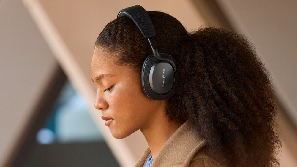 Osoba nosi czarne słuchawki nauszne z widocznym logo \'Bowers & Wilkins\'.
