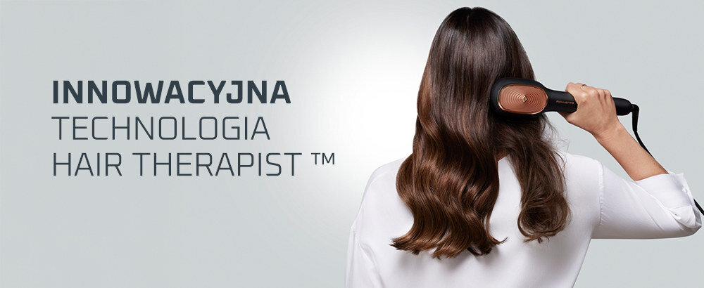 Osoba używa szczotki prostującej na długich, brązowych włosach. Obok widoczny jest tekst: \'INNOWACYJNA TECHNOLOGIA HAIR THERAPIST™\'.