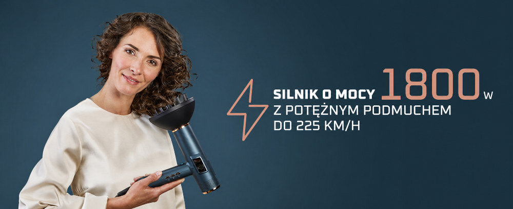 Osoba trzyma suszarkę do włosów na ciemnym tle. Obok widoczny jest tekst: \'SILNIK O MOCY 1800 W Z POTĘŻNYM PODMUCHEM DO 225 KM/H\'.