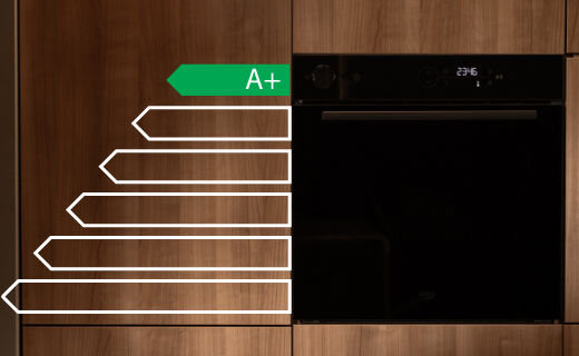 Piekarnik Beko w drewnianej kuchni z nałożoną grafiką zielonej strzałki wskazującej wysoką klasę energetyczną A+.