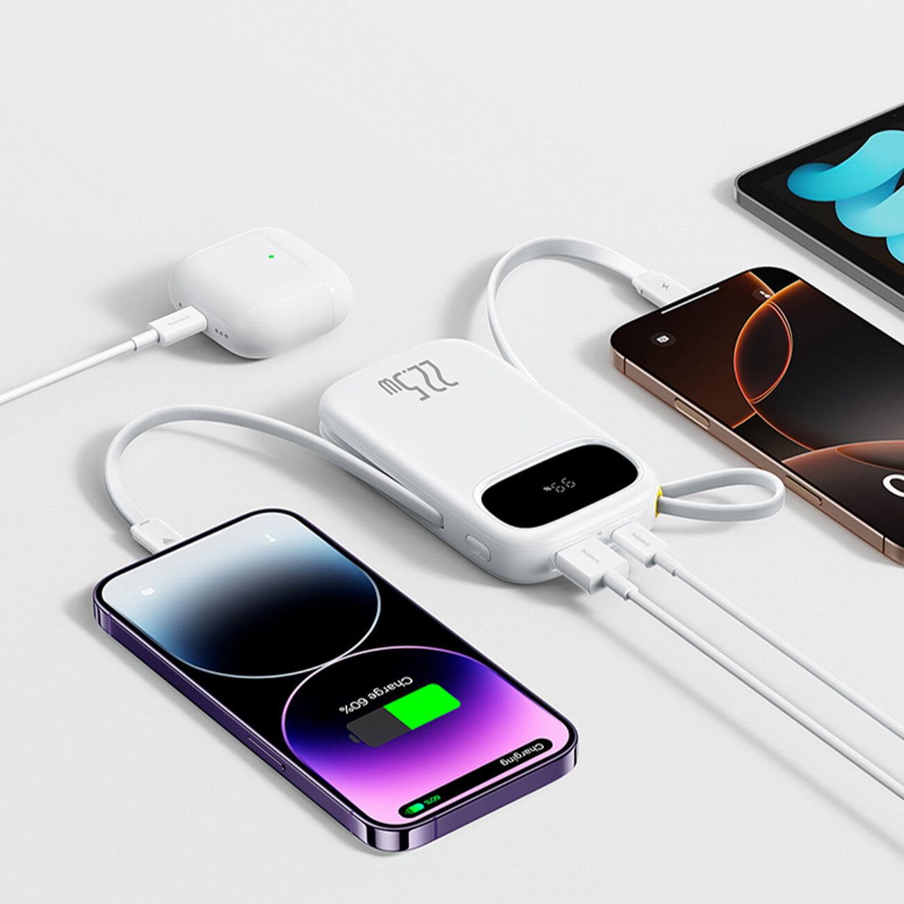 Na obrazie widoczny jest biały powerbank z wyświetlaczem pokazującym \'22.5W\', do którego podłączone są dwa smartfony i słuchawki bezprzewodowe. Smartfon na pierwszym planie pokazuje ekran ładowania z napisem \'Charging 60%\'.