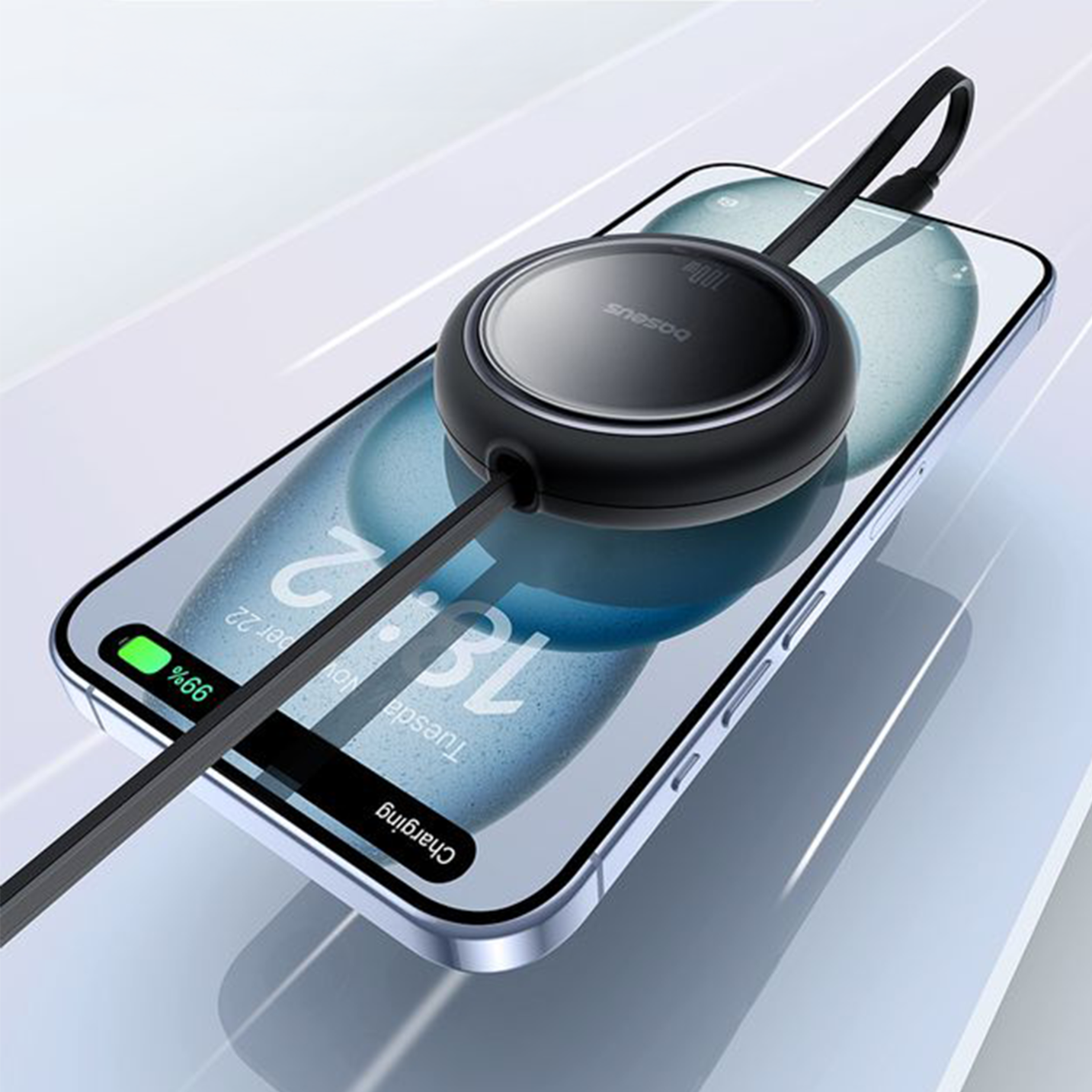 Na obrazie widać smartfon z wyświetlaczem pokazującym godzinę 13:12 i napis \'Charging\', z podłączonym czarnym kablem zwijanym. Na kablu widoczne jest logo \'Baseus\'.
