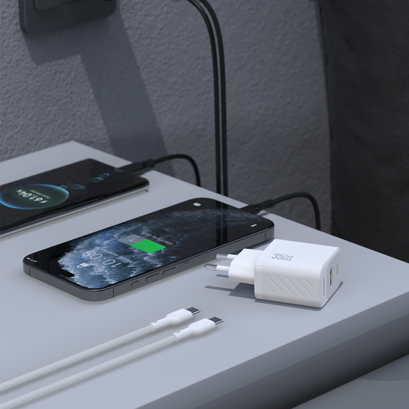 Na obrazie widać białą ładowarkę sieciową z dwoma portami USB oraz kablem USB-C, obok dwóch smartfonów z widocznym ekranem ładowania. Na ładowarce widoczny jest napis \'35W\'.