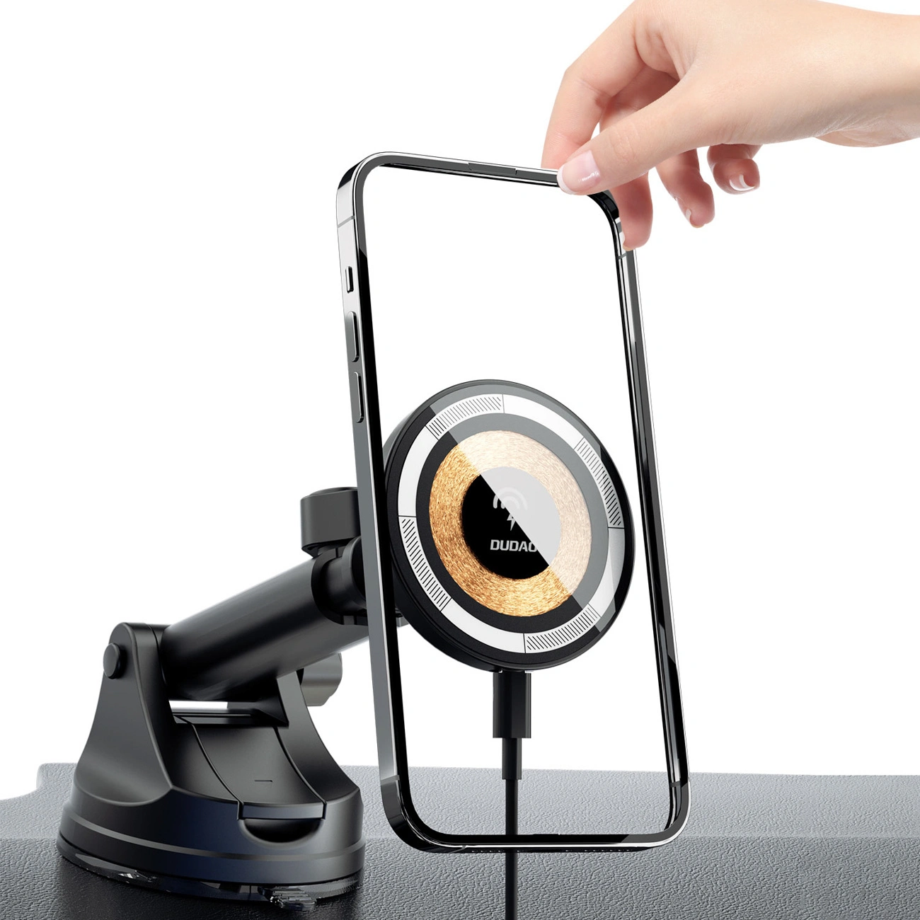 Na obrazie widoczny jest czarny uchwyt samochodowy z ładowarką bezprzewodową, na którym umieszczony jest telefon. Na ładowarce znajduje się logo \'DUDAO\'.