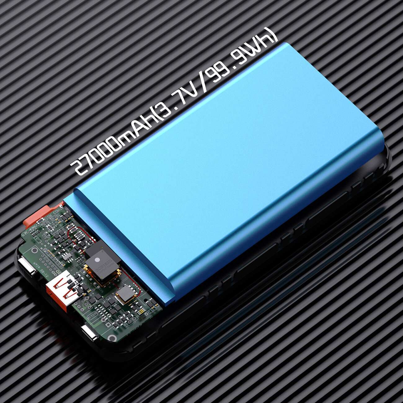 Obraz przedstawia niebieski powerbank z widoczną częścią wewnętrznej elektroniki na czarnym, prążkowanym tle. Na powerbanku widoczny jest tekst: \'27000mAh 3.7V/99.9Wh\'.
