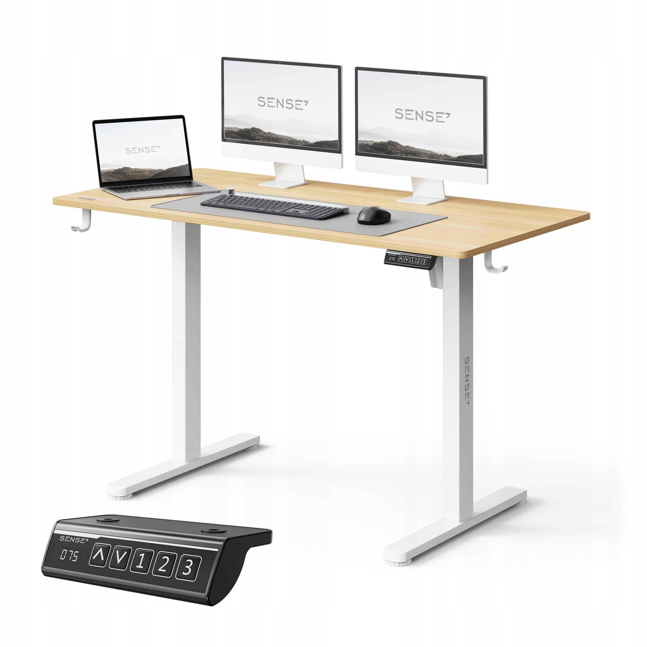 Biurko z jasnobrązowym blatem i białymi nogami, na którym znajdują się dwa monitory, laptop, klawiatura i mysz. Obok biurka widoczny jest panel sterowania z przyciskami i logo SENSE7.