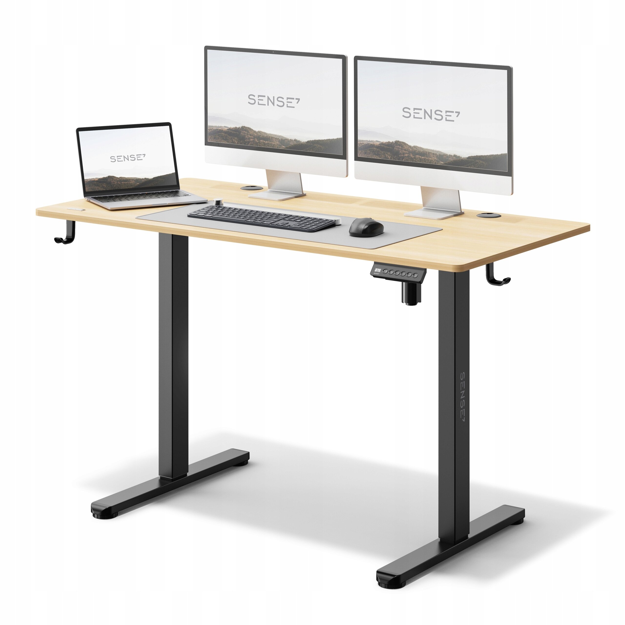 Biurko elektrycznie regulowane z jasnobrązowym blatem i czarnymi nogami, na którym znajdują się dwa monitory, laptop, klawiatura i mysz. Na ekranach widoczny jest napis \'SENSE7\'.