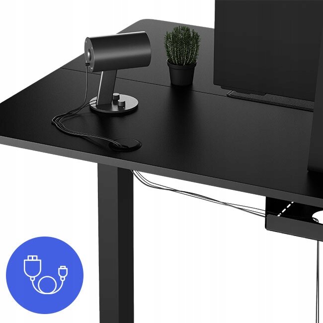 Czarne biurko z regulowaną wysokością, na którym znajduje się lampa, mała roślina w doniczce i monitor. W dolnym rogu widoczna jest ikona z symbolem kabla USB na niebieskim tle.