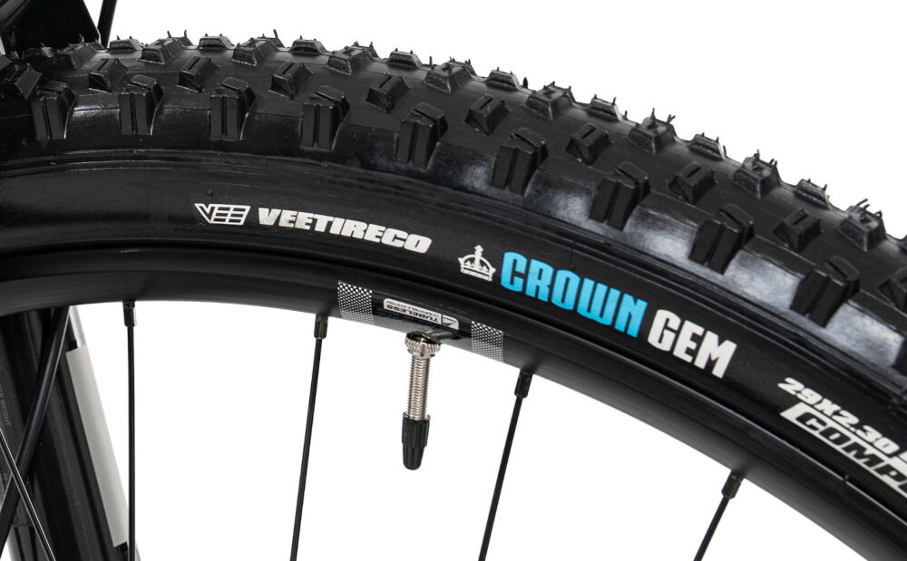 Rower górski MTB ROMET Dagger 2 29170129-B U17 29 cali Szaro-czarny zbliżenie na przednią oponę białe tło opony marki VEE TIRE w rozmiarze 29 cali z głębokim bieżnikiem przyczepność kontrola szerokie obręcze DT Swiss XM 1700 Spline 30 mm wytrzymałość i stabilność solidne piasty DT Swiss w standardzie 15x110 mm z przodu i 12x148 mm z tyłu sztywność kół sprawdzanie ciśnienia powietrza wartość na bocznej części opony