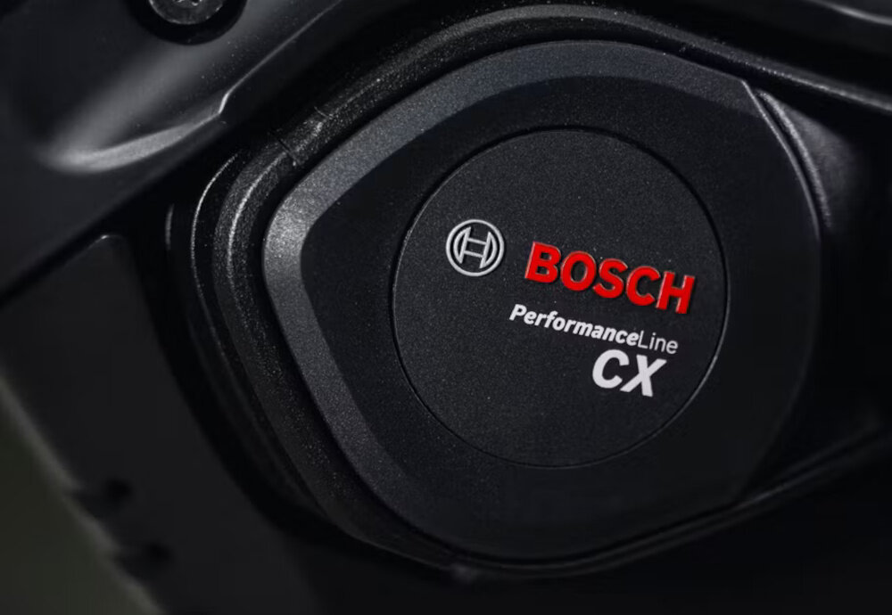 Zbliżenie na element z logo \'BOSCH Performance Line CX\' na czarnym tle.
