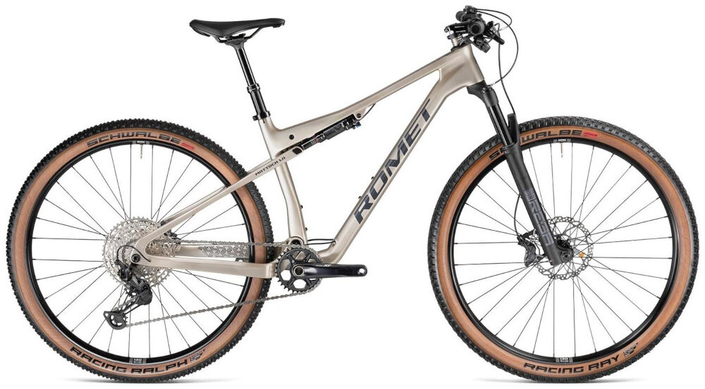 Rower górski w kolorze piaskowym z dużymi kołami i napisem \'ROMET\' na ramie. Opony mają widoczne napisy \'SCHWALBE\' i \'RACING RALPH\'.