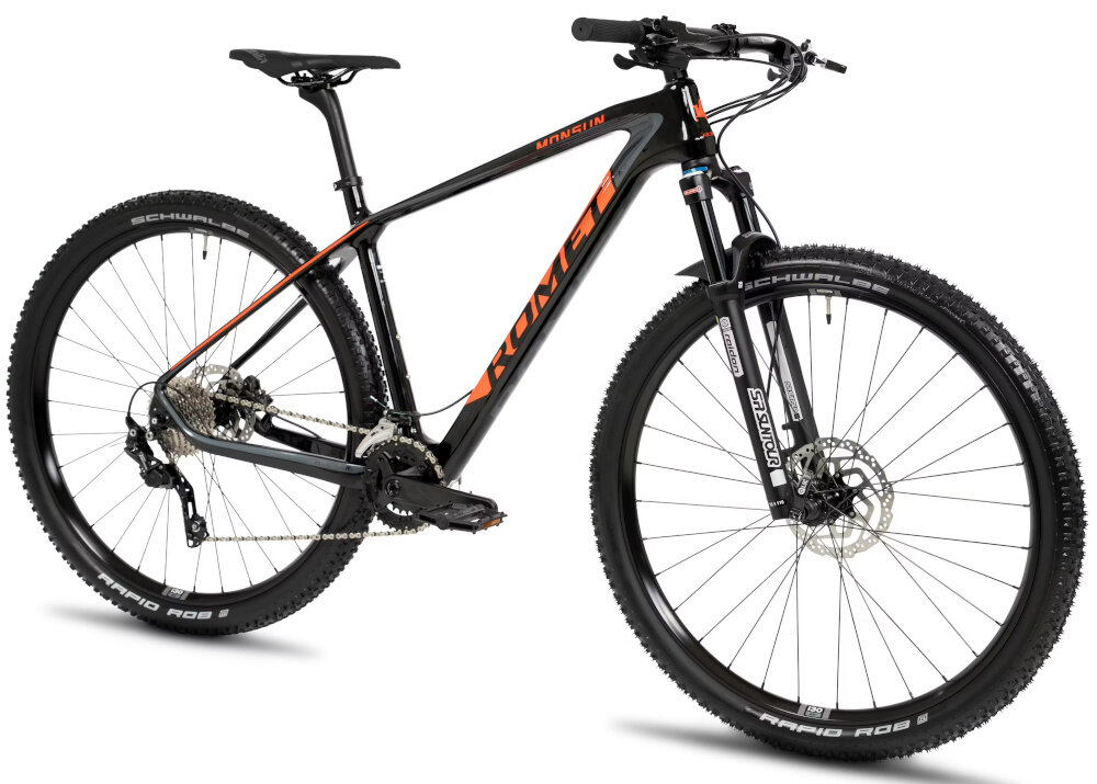 Czarny rower górski z pomarańczowymi napisami \'ROMET\' i \'MONSUN\' na ramie. Opony mają widoczne logo \'SCHWALBE\' i napis \'RAPID ROB\'.