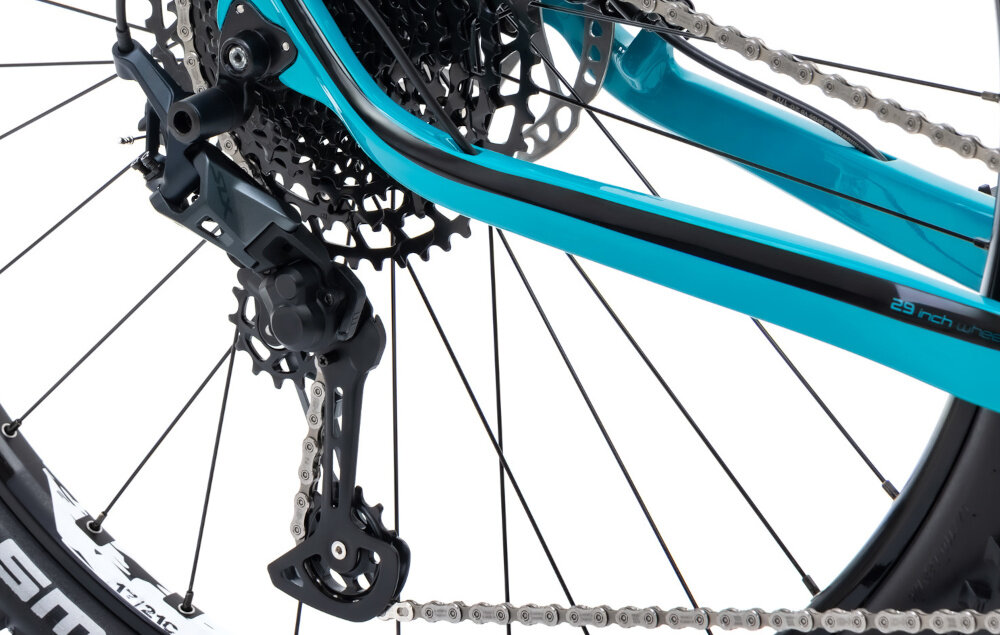 Rower górski MTB ROMET Monsun 2.0 29151342-B 1 U15 29 cali Turkusowy zbliżenie na przerzutkę białe tło widok z boku przerzutki marki SRAM 12 przełożeń duża wytrzymałość sprawne działanie zmiana biegów jest płynna i bezproblemowa tylne przerzutki SHIMANO Deore typu RD-M7100 trwałość stabilność precyzja