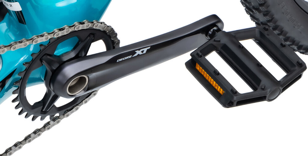 Rower górski MTB ROMET Monsun 2.0 29151342-B 1 U15 29 cali Turkusowy zbliżenie na korbę i kasetę białe tło widok z boku precyzyjny napęd oparty na komponentach renomowanej marki SHIMANO kaseta SHIMANO Deore typu CS-M6100 o szerokim zakresie 10-51T korba SHIMANO Deore XT typu FC-M8100-1 32T 170 mm
