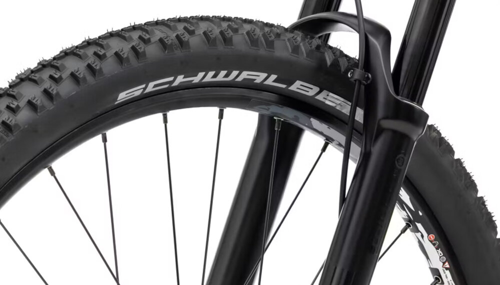 Zbliżenie na przednie koło roweru górskiego z widocznym bieżnikiem opony i napisem \'SCHWALBE\' na boku.