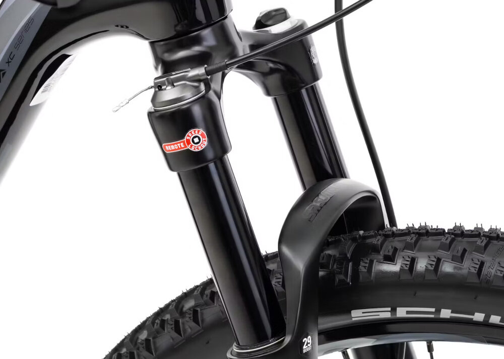 Zbliżenie na przednie zawieszenie roweru górskiego z widocznym logo \'ROMET\' na widelcu. Opona ma wyraźny bieżnik i napis \'SCHWALBE\'.