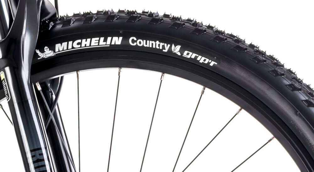 Rower górski MTB ROMET Mustang EVO 3 29170148-A U17 29 cali Czarno-zielony zbliżenie na oponę widok z boku białe tło marki MICHELIN w rozmiarze 29 cali głęboki bieżnik skutecznie wspiera jazdę ułatwia utrzymanie stabilnego toru jazdy aluminiowe, dwukomorowe obręcze sztywność niska masa piasty SHIMANO HB-TC500-B w standardzie 15x110 mm z przodu i 12x142 mm z tyłu sztywność tylnego koła stabilność regularne sprawdzanie ciśnienia powietrza wartość na bocznej części opony