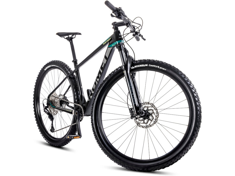 Rower górski MTB ROMET Mustang EVO 3 29190149-A U19 29 cali Czarno-zielony rower na białym tle widoczny od przodu pod skosem rowery MTB „góral” dla sportowców do jazdy wyczynowej dla amatorów zwrotne łatwo wchodzące w zakręty w mieście za miastem w lesie na łatwym i trudnym górskim szlaku w niezbyt grząskim błocie nie za głębokim piachu