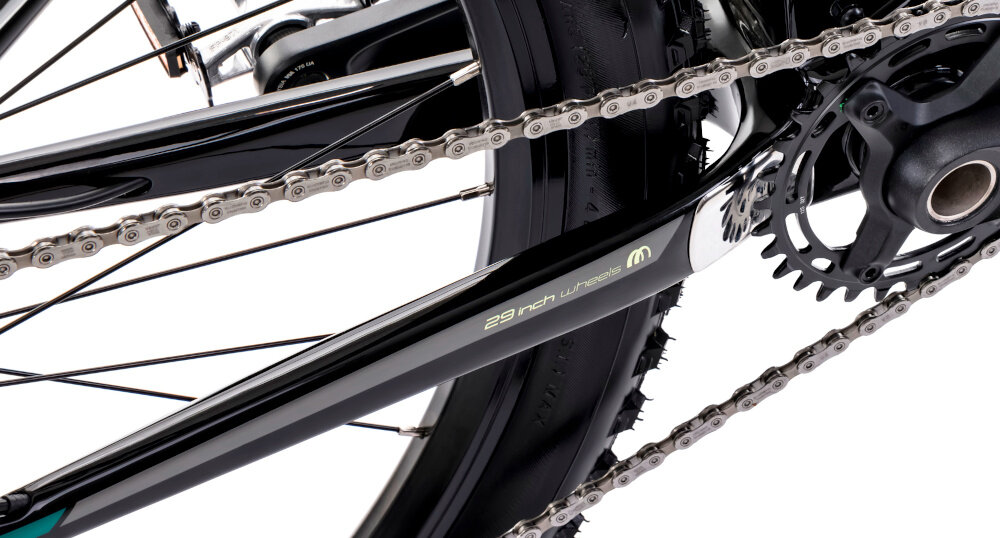 Rower górski MTB ROMET Mustang EVO 3 29190149-A U19 29 cali Czarno-zielony zbliżenie na łańcuch widok pod skosem stalowy łańcuch marki ROMET odpowiednia konstrukcja ogniw wspiera płynną współpracę z kasetą i zębatkami bardziej równomierne przenoszenie mocy mniejsze zużycie pozostałych elementów napędu