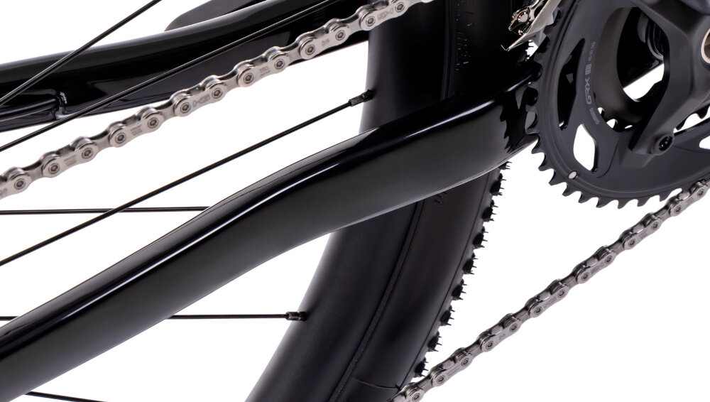 Rower gravel ROMET NYK 2.0 28460099-A U17 28 cali Fioletowy zbliżenie na łańcuch białe tło stalowy łańcuch marki ROMET konstrukcja ogniw wspiera płynną współpracę z kasetą i zębatkami bardziej równomierne przenoszenie mocy mniejsze zużycie pozostałych elementów napędu