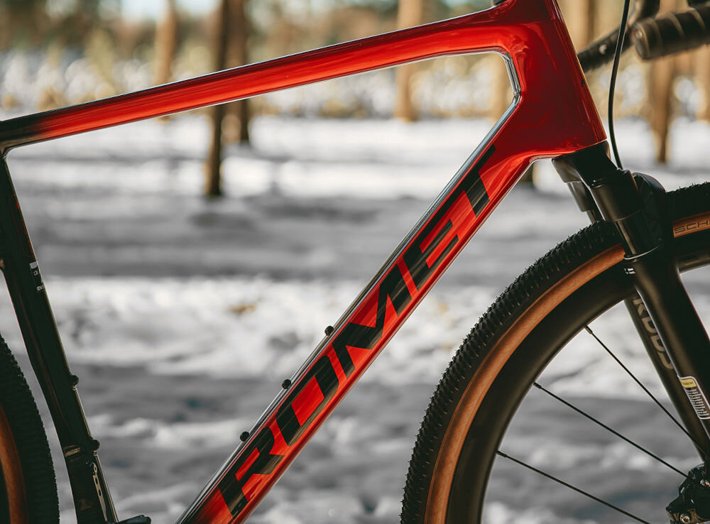 Rower gravel ROMET NYK 3.0 SRAM 28540363-A U21 28 cali męski Czerwono-czarny zimowa sceneria rower widoczny bokiem ustawiony na śniegu w lesie zbliżenie na ramę 21-calowa karbonowa rama znacznie niższa waga roweru waga 9,9 kg łatwo przenieść go odpowiednia sztywność wybór rozmiaru ramy Twój wzrost mierzony w zrelaksowanej pozycji typ roweru dla osób o wzroście od 165 do 175 cm