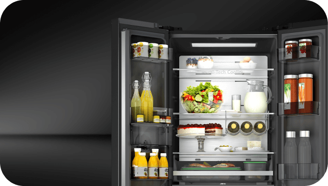 Otwarta lodówka z różnymi produktami spożywczymi na półkach, w tym napoje, sałatka, ciasto i jajka. Widoczny napis \'Metal Tech Cooling\'.