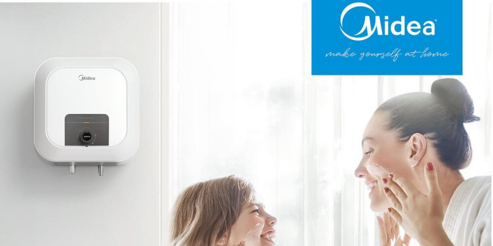 Na obrazie widoczny jest biały bojler elektryczny z logo \'Midea\' zamontowany na ścianie. Obok znajduje się logo \'Midea\' z napisem \'make yourself at home\'.