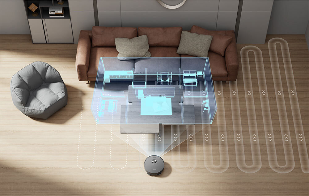 Na drewnianej podłodze znajduje się robot sprzątający, który wizualizuje mapę pomieszczenia z meblami. W tle widoczna jest sofa z poduszkami i fotel.