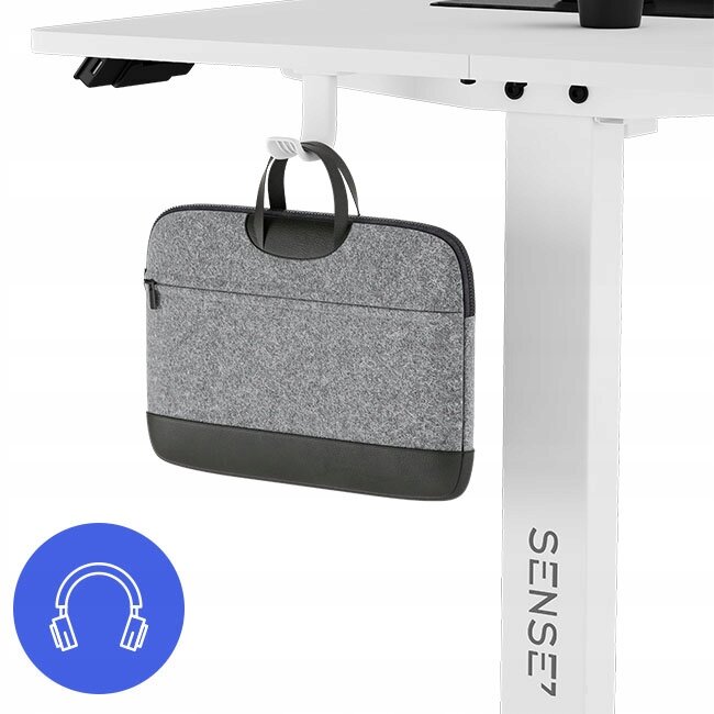 Białe biurko z regulacją wysokości, na którym wisi szara torba na laptopa. Na nodze biurka widoczny jest napis \'SENSE7\'.