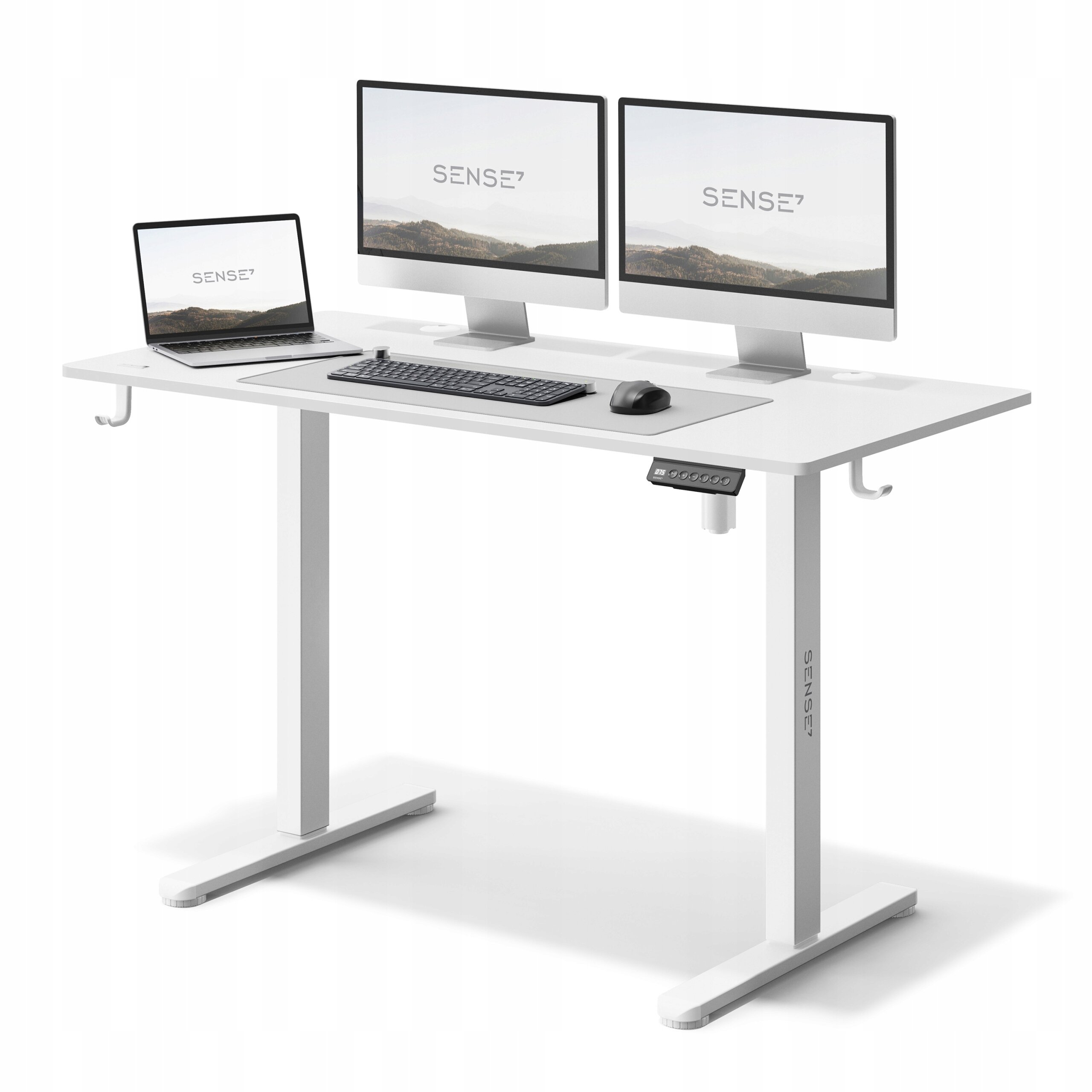Białe biurko z elektryczną regulacją wysokości, na którym znajdują się dwa monitory, laptop, klawiatura i mysz. Na biurku widoczne jest logo \'SENSE7\'.
