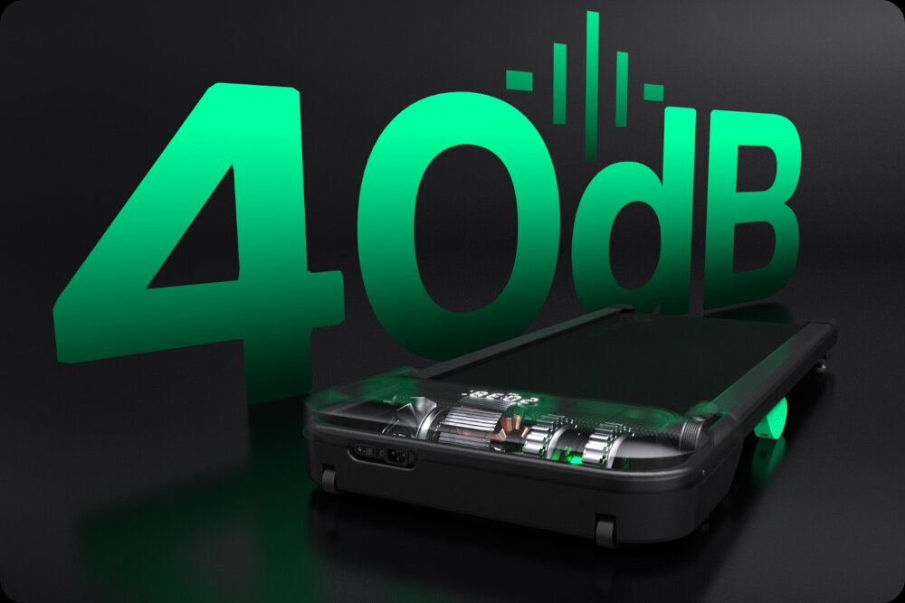 Obraz przedstawia bieżnię elektryczną z widocznymi elementami mechanicznymi, obok której znajduje się duży napis \'40 dB\' w zielonym kolorze. Tło jest ciemne, co podkreśla kontrast napisu i bieżni.