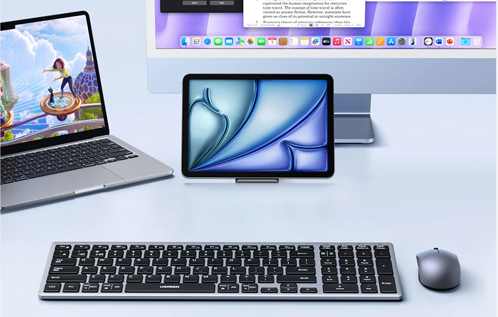 Na biurku znajduje się klawiatura i mysz bezprzewodowa obok laptopa, tabletu i monitora. Na klawiaturze widoczne jest logo \'UGREEN\'.