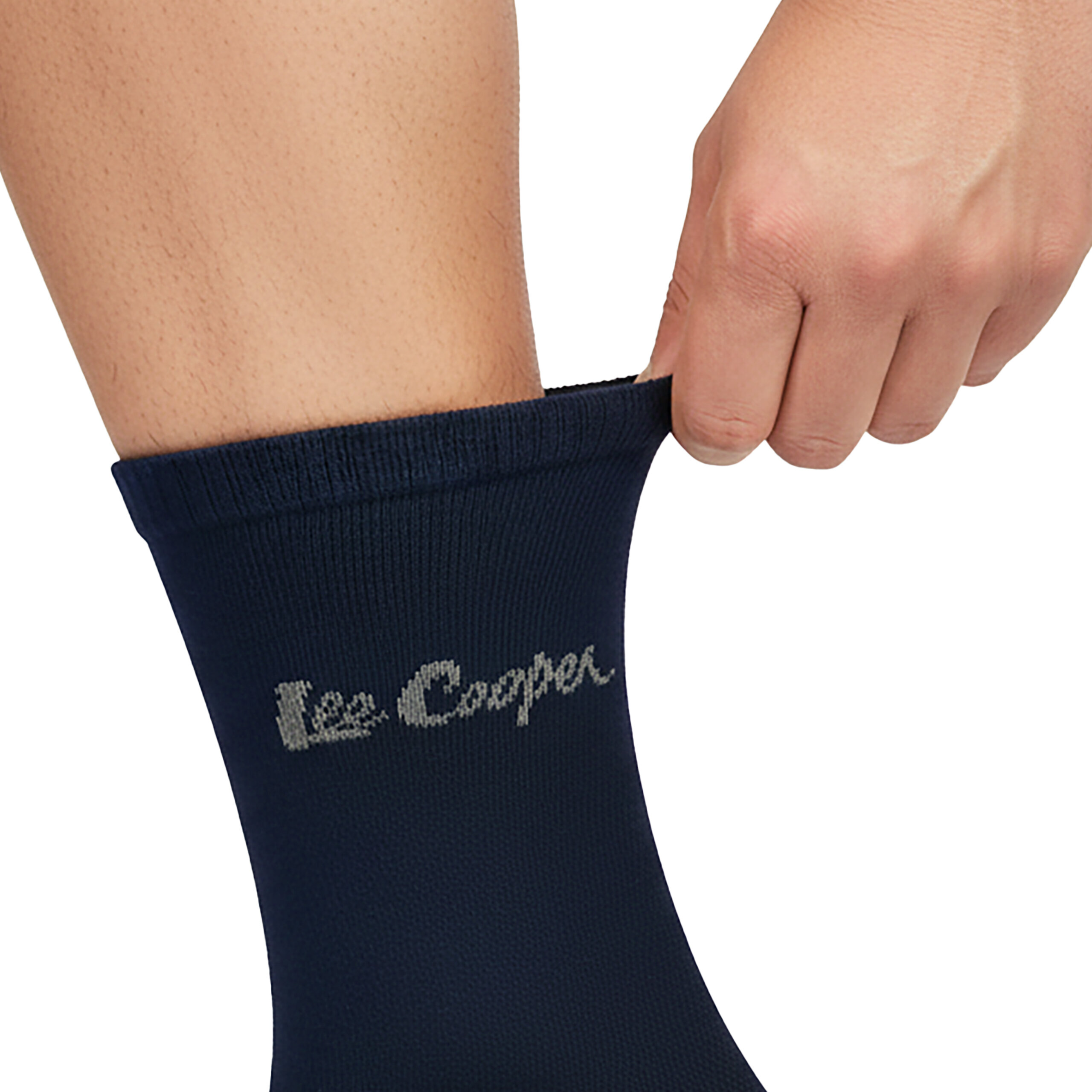 Osoba zakłada ciemnoniebieską skarpetę z napisem \'Lee Cooper\'.