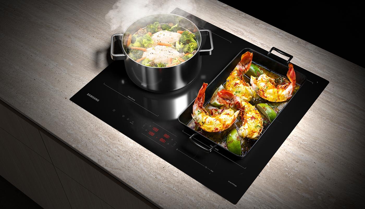 Na zdjęciu pokazano przygotowywanie dwóch różnych potraw w dużym garnku i obszernej brytfannie, które możliwe jest dzięki płycie z szerokimi strefami gotowania