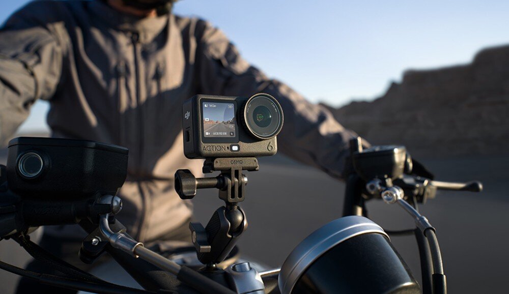 Kamera sportowa DJI Osmo Action 6 Kamera sportowa zamocowana na kierownicy motocykla z widocznym motocyklistą w tle, cechy, zalety, przeznaczenie