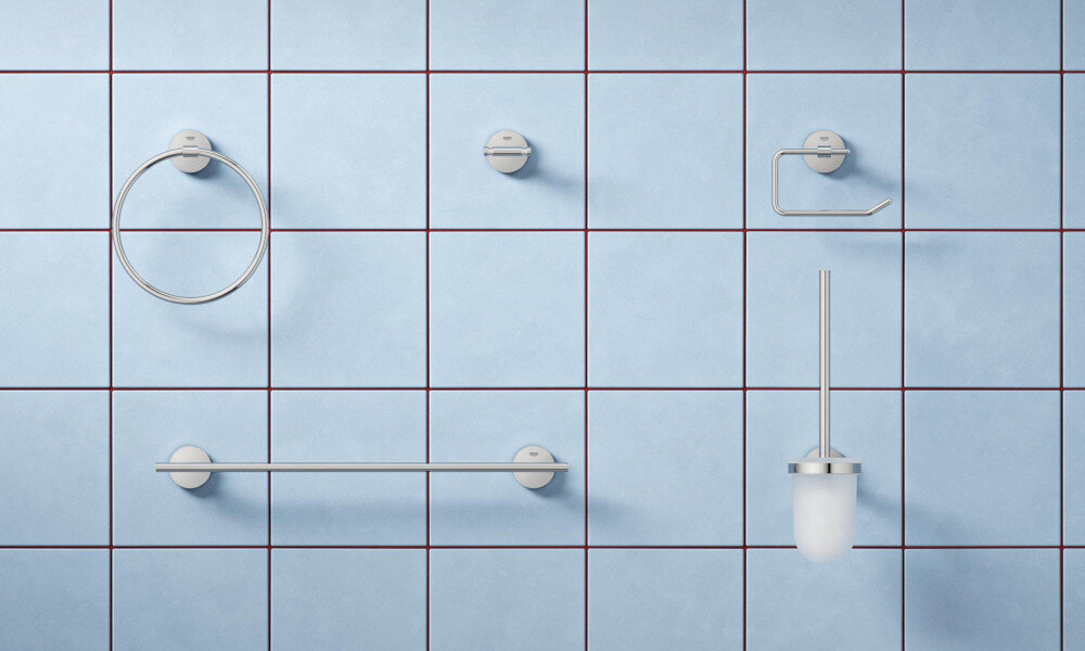 BATERIA UMYWALKOWA ROZMIAR S GROHE BAUEDGE 23757000 CHROM Zestaw metalowych akcesoriów łazienkowych (uchwyt na ręcznik, wieszak, uchwyt na papier, szczotka WC) zamontowanych na niebieskiej ścianie z płytek akcesoria GROHE dopasowany kolor spójny design łazienki wieszaki uchwyty dozowniki