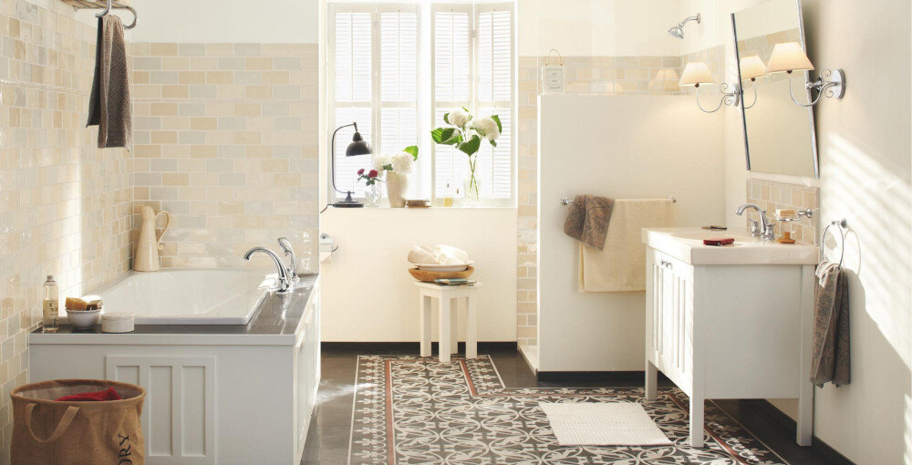 UCHWYT NA PAPIER GROHE ESSENTIALS Authentic 40657001 CHROM Jasna, klasyczna łazienka z wanną, umywalką i lustrem; widoczne są ręczniki, dekoracje oraz naturalne światło wpadające przez okno, tworzące przytulne wnętrze wykończenie elegancki design stylowe akcesoria łazienkowe