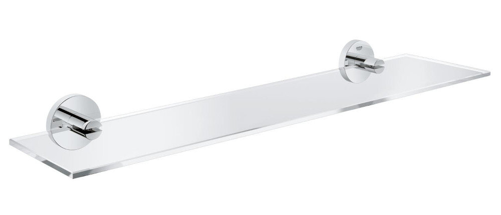 PÓŁKA SZKLANA GROHE ESSENTIALS 40799001 CHROM Szklana półka łazienkowa zamontowana na ścianie z jasnego marmuru, na której stoją kosmetyki i zwinięte ręczniki. Dłoń sięga po ręcznik, a w tle widoczna jest umywalka z chromowaną baterią i lustro