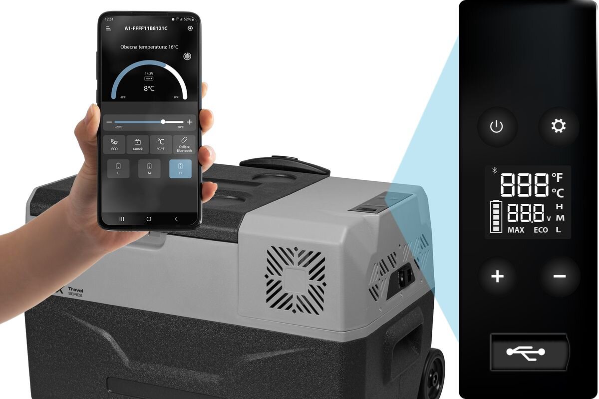Lodówka turystyczna z szarym i czarnym wykończeniem, obok której znajduje się ręka trzymająca smartfon z aplikacją pokazującą temperaturę 8°C. Obok widoczny jest panel sterowania z wyświetlaczem cyfrowym pokazującym temperaturę w stopniach Fahrenheita i Celsjusza oraz przyciski z symbolami zasilania i USB.
