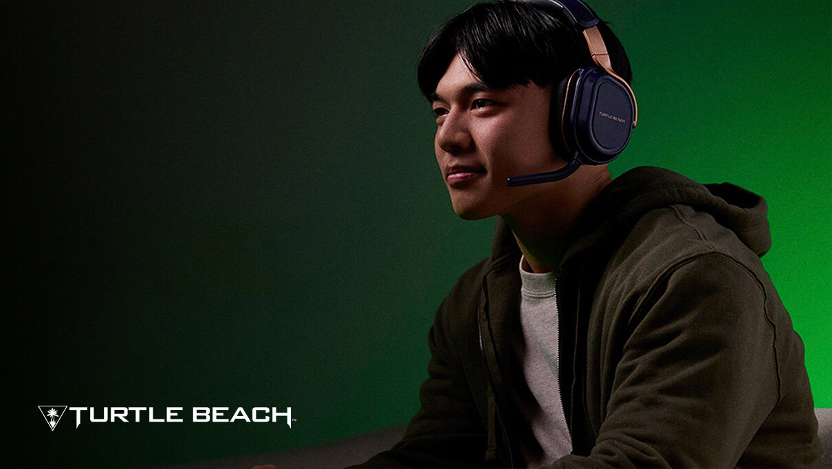 Osoba nosi słuchawki z mikrofonem, siedząc na tle zielonej ściany. W lewym dolnym rogu widoczne jest logo \'TURTLE BEACH\'.
