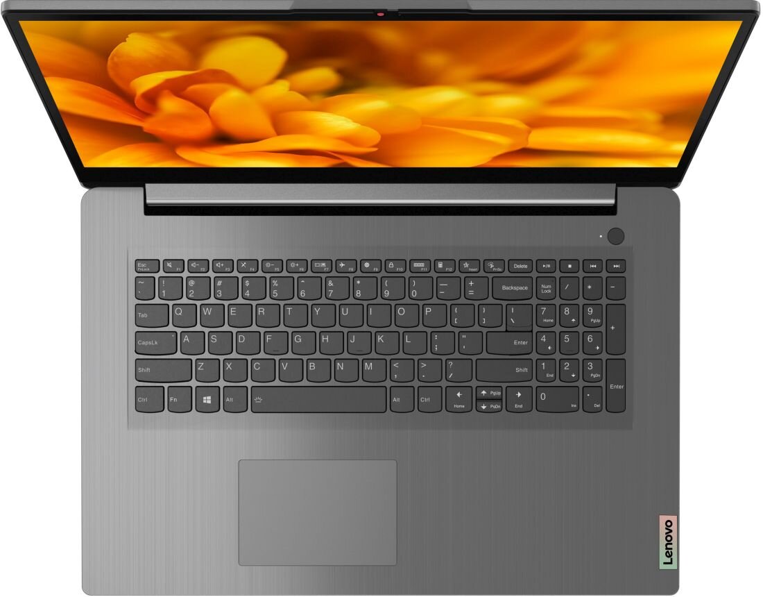 Laptop z otwartym ekranem, na którym widoczny jest obraz żółtych kwiatów. Na obudowie znajduje się logo Lenovo, a klawiatura jest pełnowymiarowa z klawiszami numerycznymi.