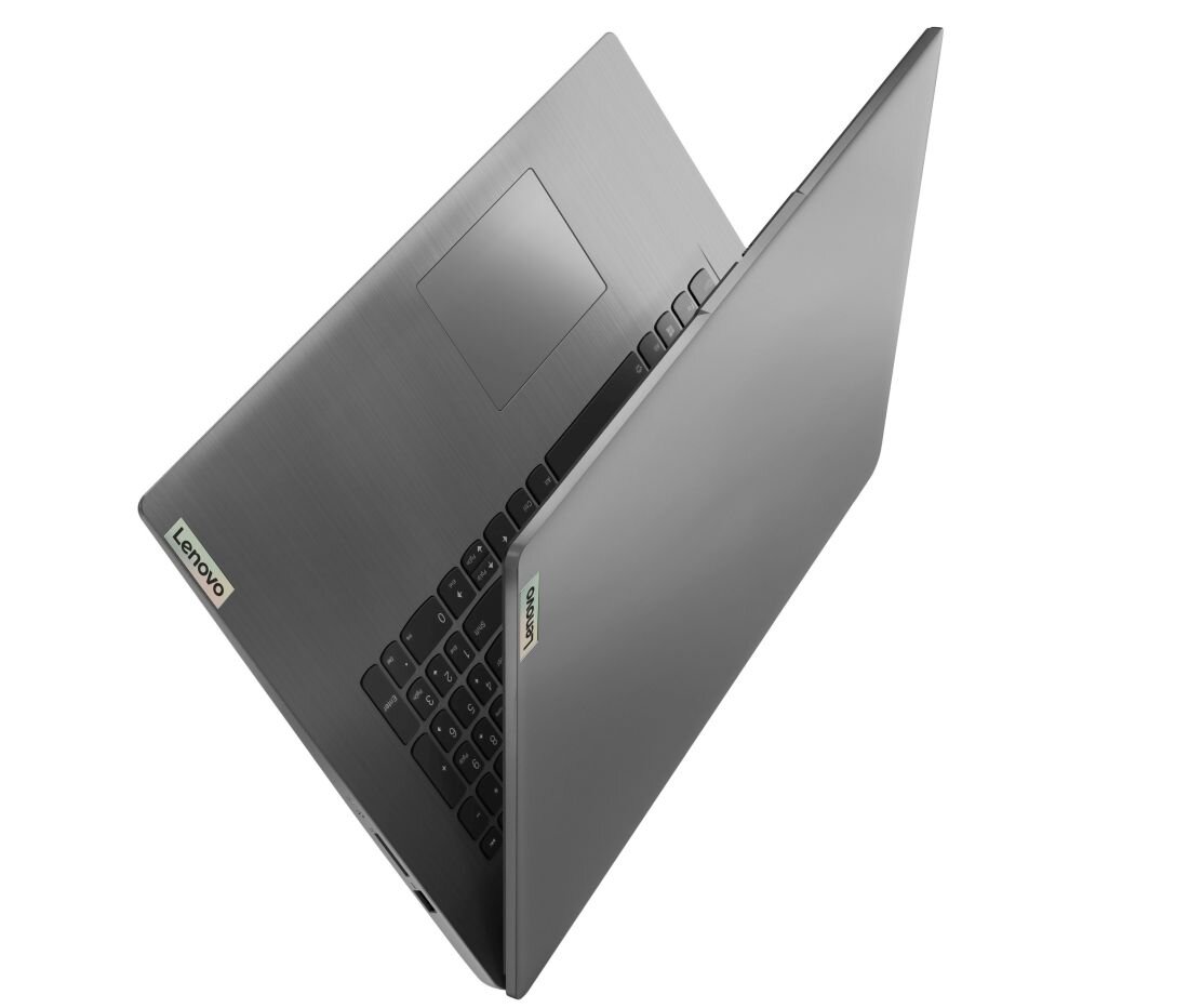 Laptop w kolorze szarym z widocznym logo \'Lenovo\' na obudowie. Urządzenie jest częściowo otwarte, ukazując klawiaturę i touchpad.