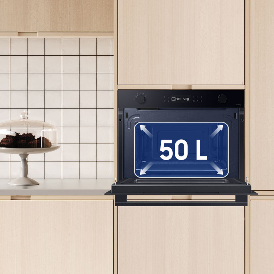 Kuchnia z jasnymi kafelkami i beżową zabudową, w której została umieszczona kuchenka mikrofalowa do zabudowy Samsung. Urządzenie dostępne jest w ofercie sklepu Media Expert.