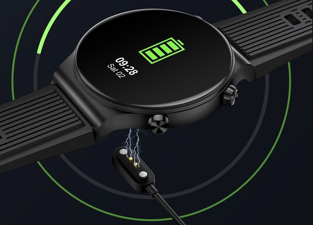 Czarny smartwatch z okrągłym wyświetlaczem pokazuje ikonę baterii i czas 09:28, Sat 02. Obok zegarka znajduje się magnetyczna ładowarka z widocznymi iskrzeniami.