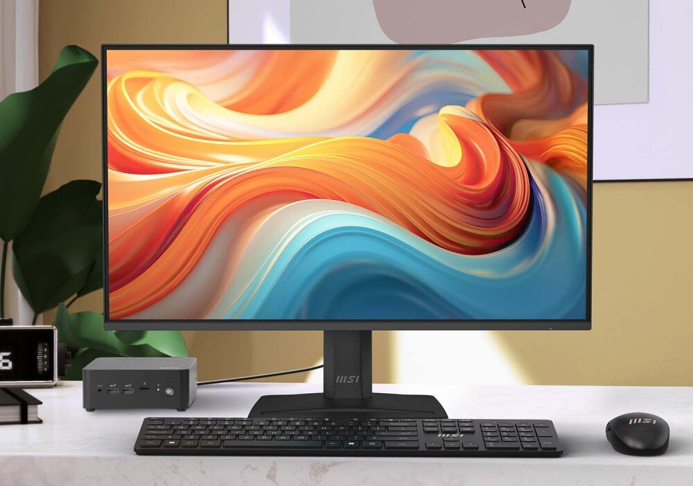 Monitor MSI Pro MP272 E14C Monitor ustawiony frontalnie na jasnym blacie roboczym w otoczeniu rośliny doniczkowej i akcesoriów biurowych, prezentujący kolorową grafikę z motywem fal, parametry, przekątna, cechy