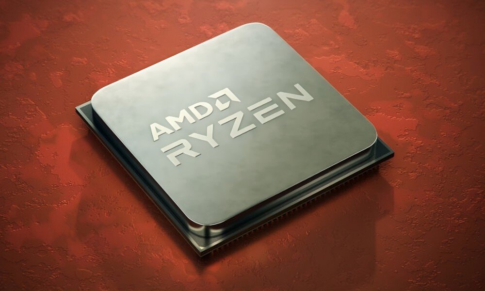 Na obrazie widoczny jest procesor z napisem \'AMD RYZEN\' na metalicznej powierzchni. Tło jest w kolorze czerwonym z teksturą przypominającą skórę.