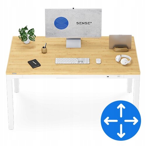 Na biurku z bambusowym blatem znajduje się monitor z logo \'SENSE7\', klawiatura, mysz, słuchawki, notes, roślina w doniczce i kubek. W prawym dolnym rogu widoczna jest niebieska ikona z białymi strzałkami wskazującymi kierunki.